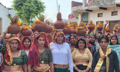 कलश यात्रा के दौरान सिर पर कलश लिए आगे बढ़ती महिला श्रद्धालु