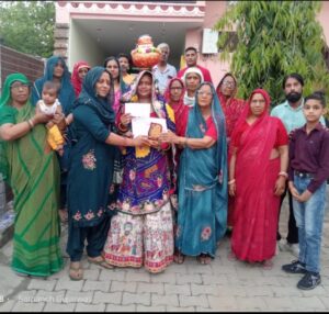 सागरपुर गांव में नवजात कन्या की माता को सम्मानित करते हुए सोसाइटी पदाधिकारी।