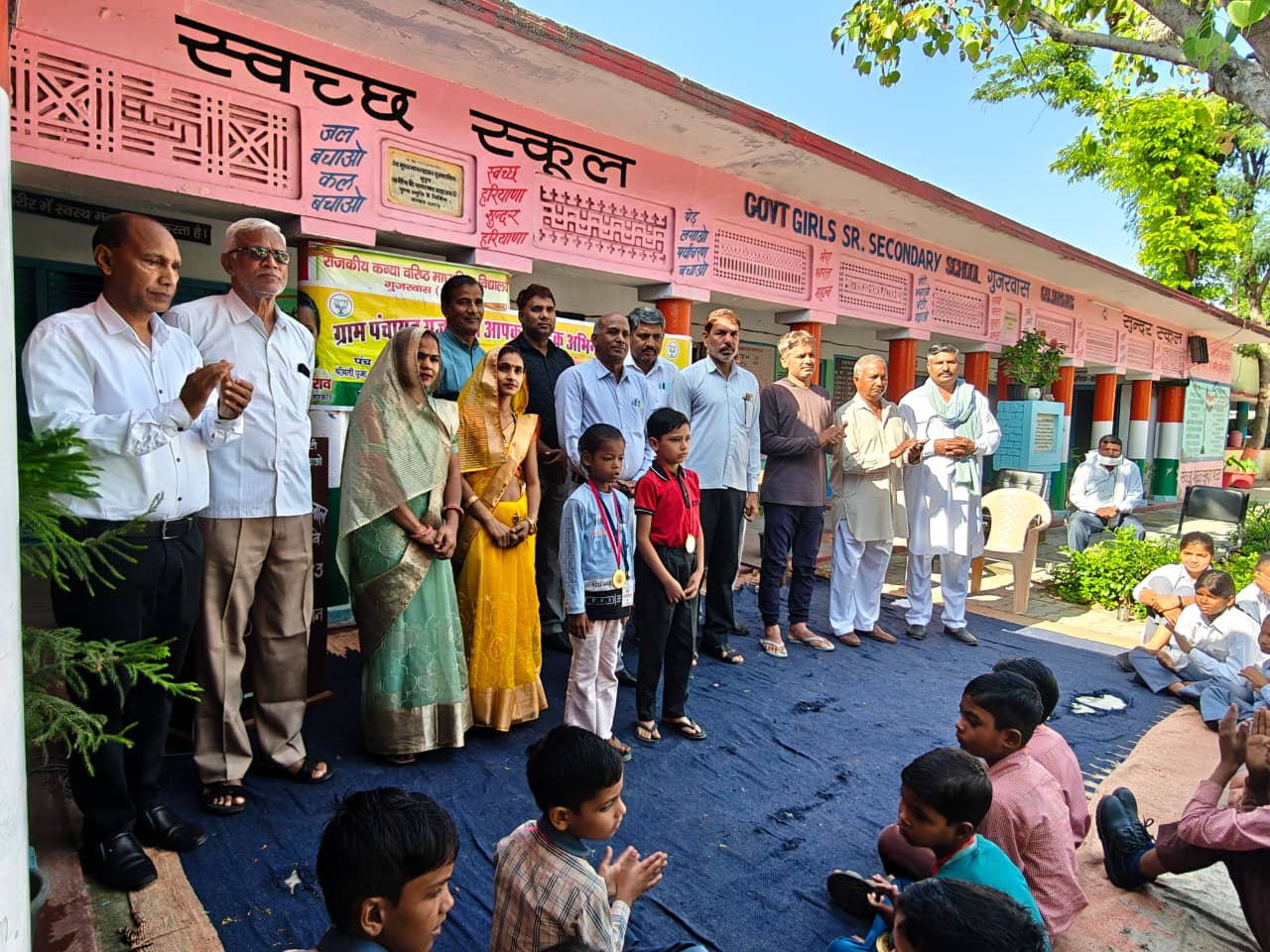 गुजरवास में निपुण परीक्षा में सफल छात्रों को मेडल पहनाकर सम्मानित करते अतिथि।