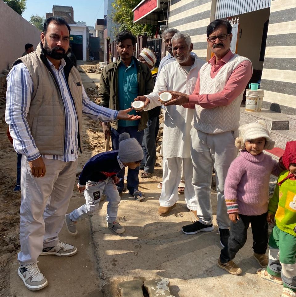 गली में सड़क निर्माण शुरू होने पर ग्रामीणों ने खुशी जताते हुए विधिवत किया उद्घाटन।