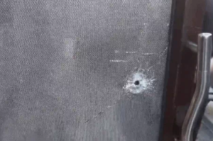 शीशे में लगी गोली का निशान।